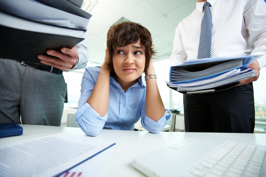 Office lady being scared because of too much paperwork to do